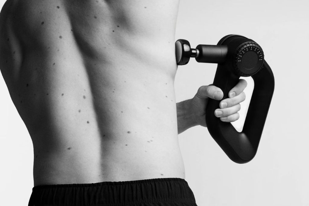 En man som masserar skuldrorna med Flowgun Ultra