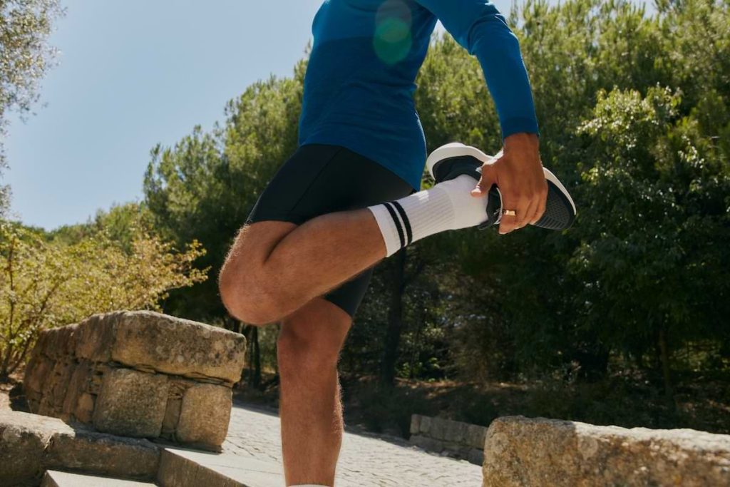 Man som använder Oura ring vid stretching inför en löptur