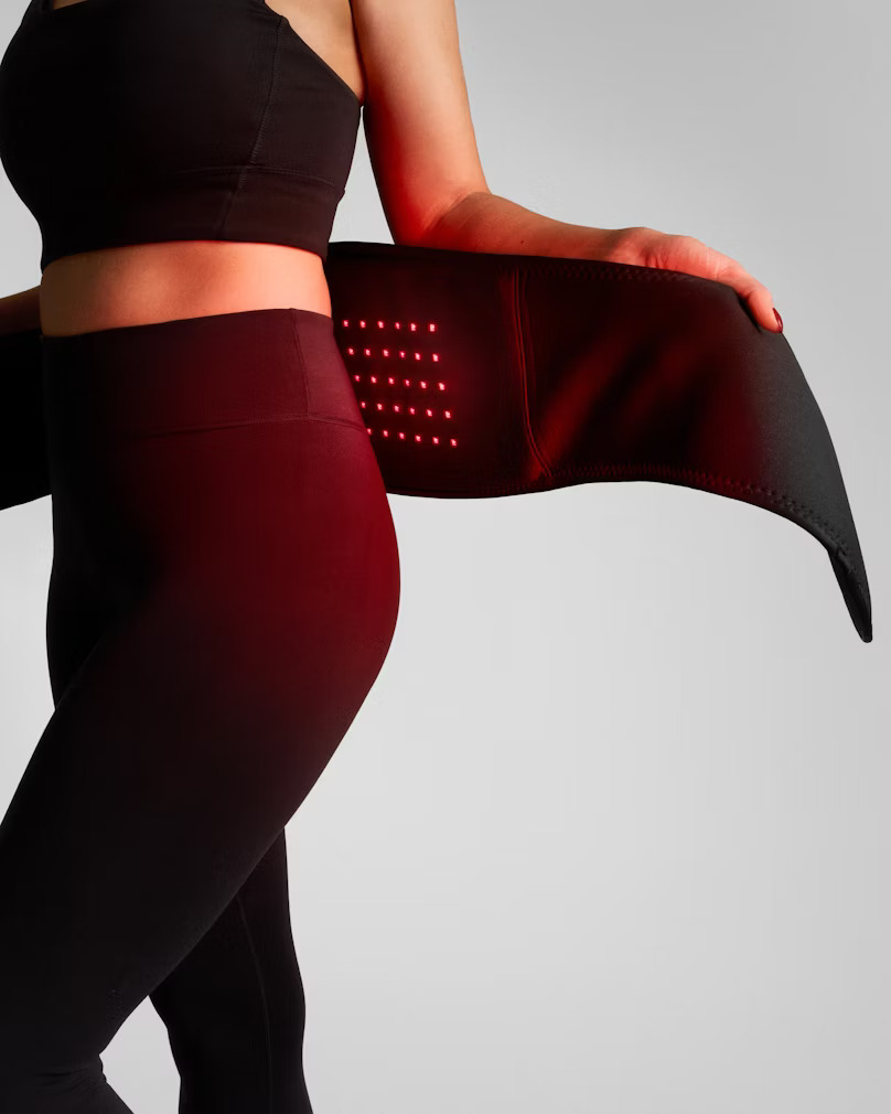 Kvinna som använder rödljusbälte av märke Flowtherma Belt